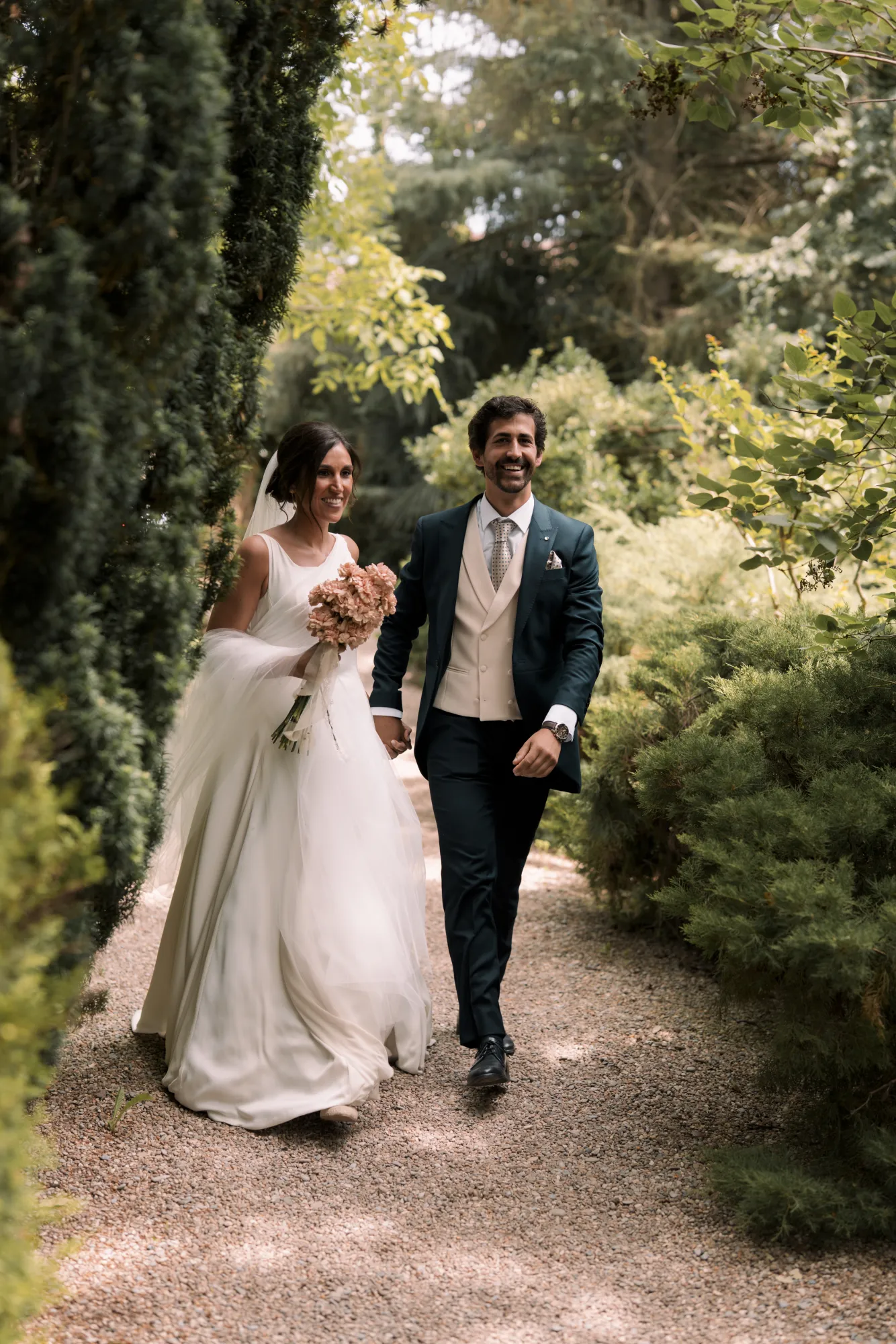 Los novios caminan entre árboles